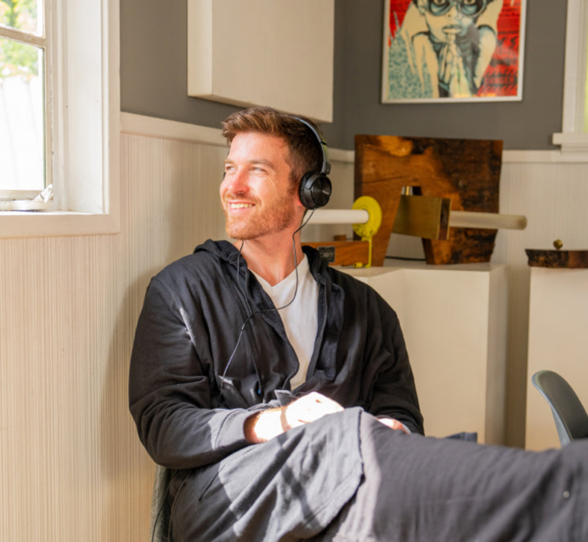 Man wearing DudeRobe relaxing with headphones at home